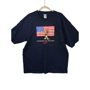 May include: A white ceramic mug with a black handle and the text "But First, Coffee" in a bold, black font. The mug is set against a blurred background, suggesting a cozy setting.