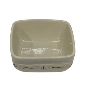 May include: Off-white ceramic square dish with rounded corners. The dish has a basket weave design around the rim and is decorated with small, dark red floral accents. The interior is smooth and glossy.