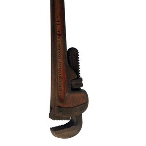 May include: A vintage 35.56 cm pipe wrench with a rusty red finish. The wrench has a curved jaw and a toothed grip, with the text "THE RIDGE TOOL CO. ELYRIA, OHIO U.S.A. 14"" printed on the handle.