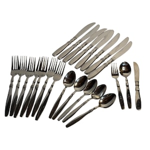 May include: A collection of stainless steel silverware, including forks, knives, and spoons. The silverware has a simple, elegant design with a polished finish. The set includes multiple place settings, ideal for a dinner party.