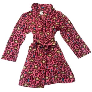 May include: Pink fleece robe with a leopard print pattern and monkey face graphics. The robe has long sleeves, a shawl collar, and a matching belt. The robe is approximately 48 inches long.