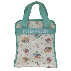 May include: A white tote bag with a repeating Peter Rabbit pattern featuring small rabbits and flowers. The bag has mint green fabric handles and a matching mint green horizontal strap across the front with the text PETER RABBIT printed in white.