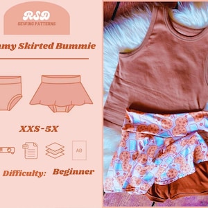 May include: A peach-colored tank top and a pair of brown shorts with a cookie-themed skirt overlay. The image also features a sewing pattern design with the text "Mommy Skirted Bummie" and "XXS-5X". The difficulty level is listed as "Beginner".