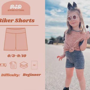 May include: A little girl wearing gray biker shorts and a knotted pink and gray shirt. The image also shows a sewing pattern for biker shorts, with the text "Biker Shorts" and "Difficulty: Beginner". The pattern is for sizes 0/3-9/10.