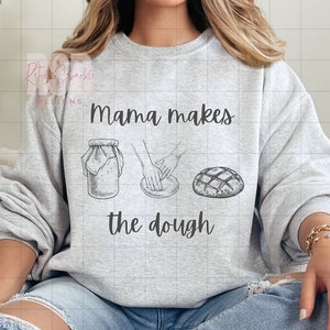 Puede incluir: Una sudadera gris con el texto "Mama makes the dough" e ilustraciones de un frasco de masa madre, manos amasando masa y una hogaza de pan.