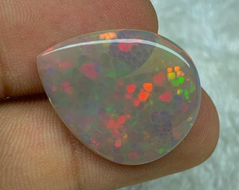 May include: A teardrop-shaped opal gemstone with a white base and a colorful play of color, including red, orange, green, and blue.