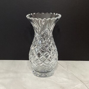 May include: A clear glass vase with a cut crystal design. The vase has a wide mouth and a narrow base.