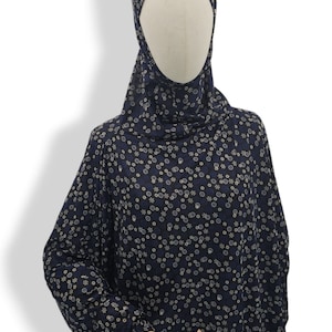 May include: A navy blue prayer dress with a white floral pattern. The dress has long sleeves and a high neck.