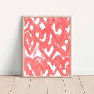 May include: A framed print featuring a white background with a pattern of pink hearts painted in a brushstroke style.