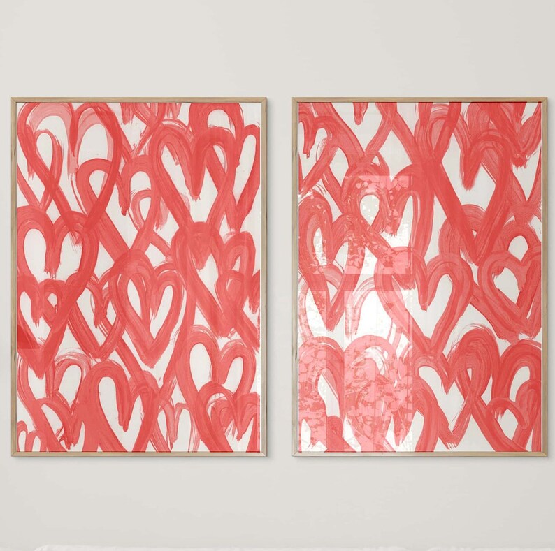 May include: Two framed prints featuring a white background with a pattern of red painted hearts.