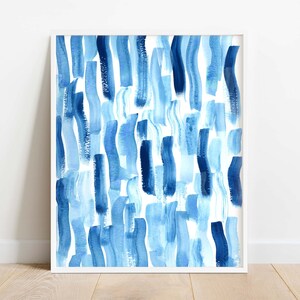 Puede incluir: Impresi&oacute;n art&iacute;stica enmarcada con un dise&ntilde;o abstracto de pinceladas verticales en tonos azules sobre un fondo blanco. La obra de arte se presenta en un marco blanco, ofreciendo un aspecto contempor&aacute;neo y minimalista. Ideal para la decoraci&oacute;n del hogar u oficina.