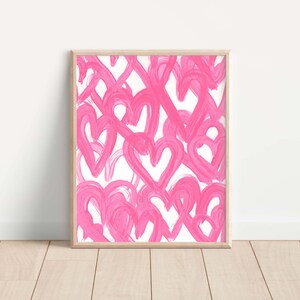 May include: A framed print with a pink and white abstract design featuring a pattern of overlapping hearts.