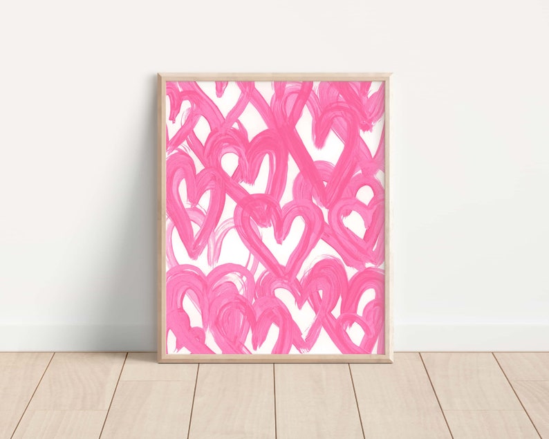 May include: A framed print with a pink and white abstract design featuring a pattern of overlapping hearts.