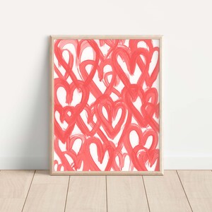 May include: A framed print with a white background and a pattern of overlapping pink hearts.