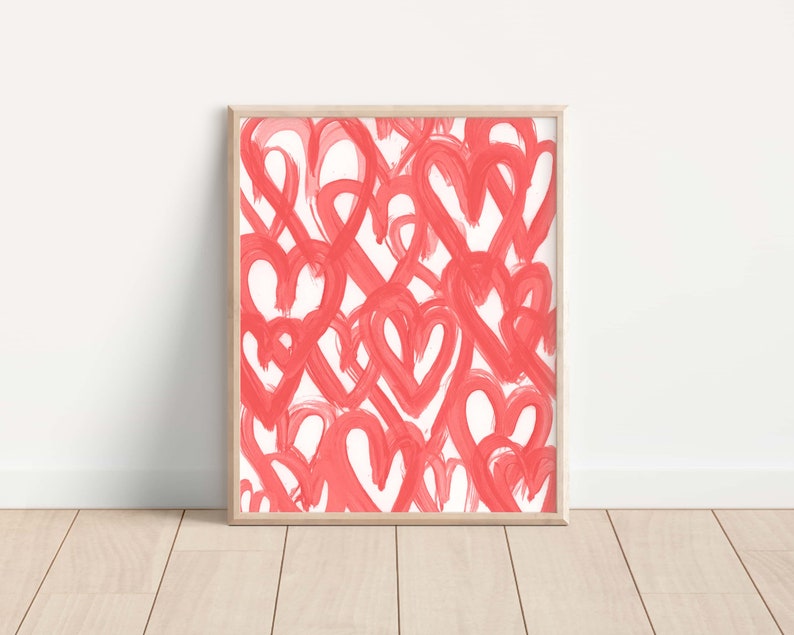May include: A framed print with a white background and a pattern of overlapping pink hearts.