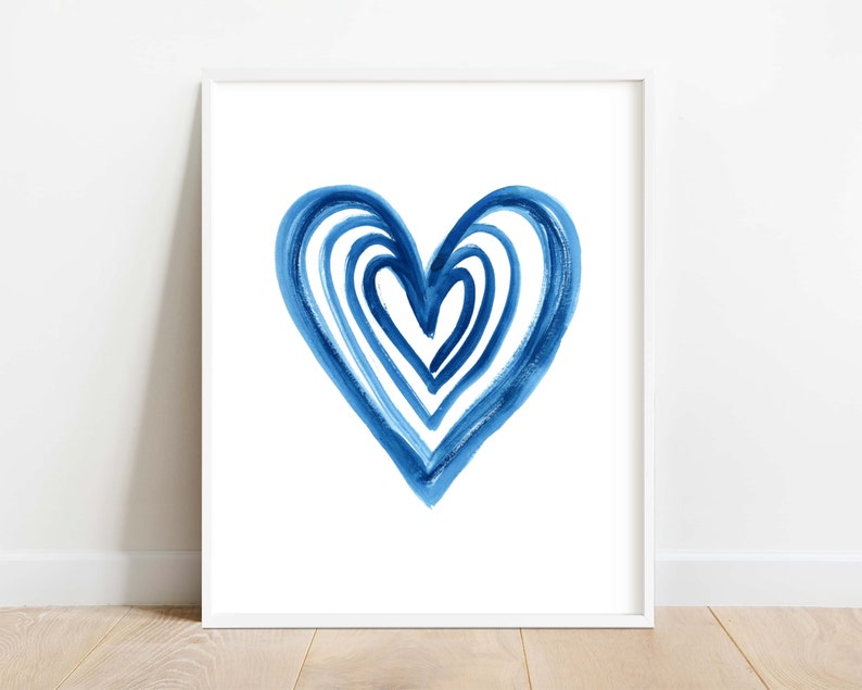 Puede incluir: Impresi&oacute;n art&iacute;stica enmarcada con un dise&ntilde;o de coraz&oacute;n azul en acuarela. El coraz&oacute;n est&aacute; compuesto por pinceladas superpuestas en diferentes tonos de azul, creando un efecto texturizado sobre un fondo blanco. La obra est&aacute; enmarcada en un marco blanco.