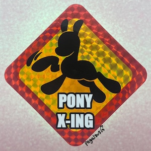 May include: A diamond-shaped sticker with a red and yellow reflective background. A black silhouette of a pony is leaping across the center. The words "PONY X-ING" are in white block letters. The artist's signature is in the bottom right corner.