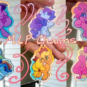 May include: Six colourful acrylic charms featuring characters from the My Little Pony franchise. The charms are translucent and have a holographic effect. The characters are Twilight Sparkle, Rainbow Dash, Pinkie Pie, Fluttershy, Rarity, and Applejack. The charms are attached to key rings.