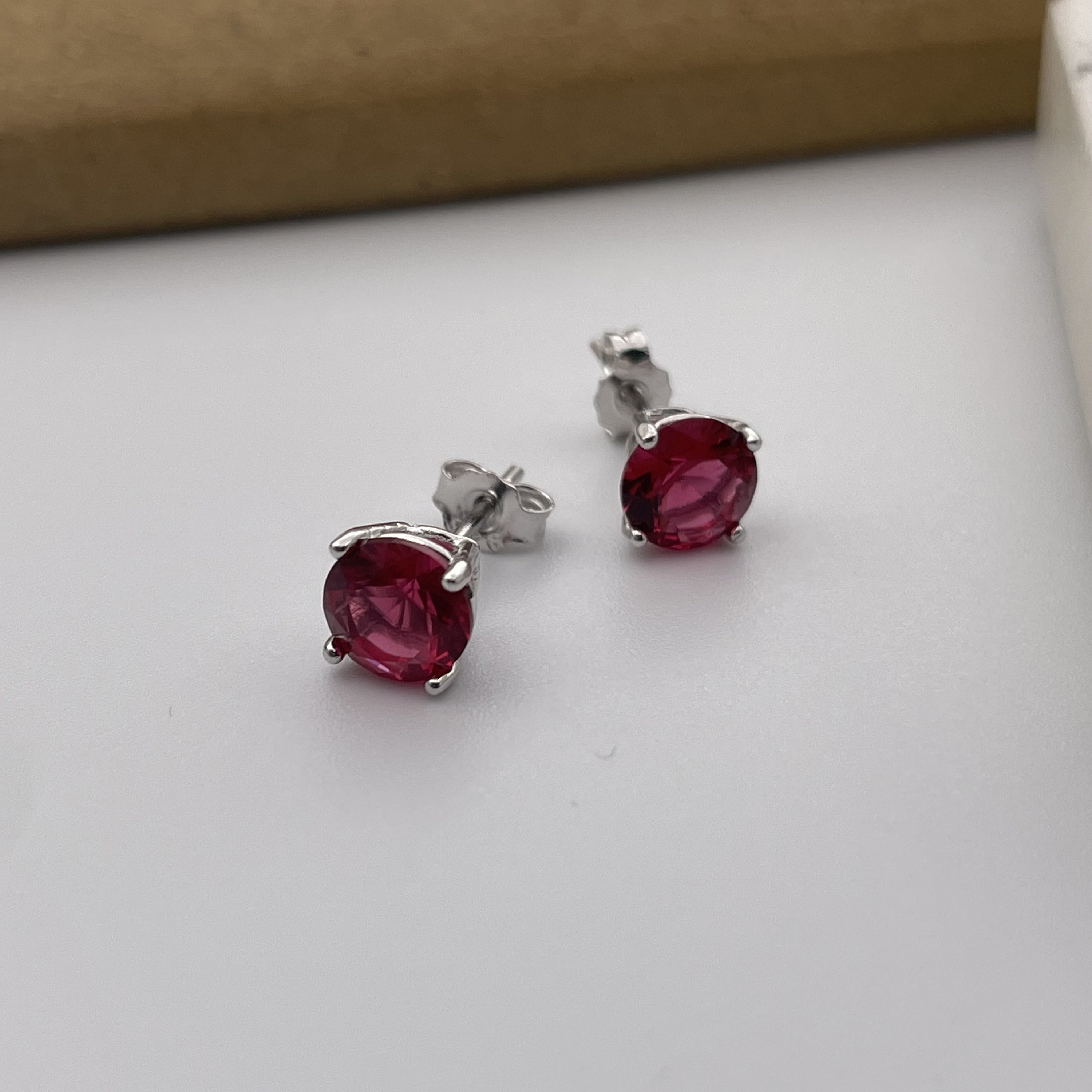 Stud earrings made of steel, black hemisphere with dark red stone |  Jewellery Eshop EU