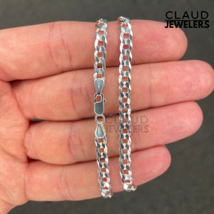 May include: A silver curb chain necklace with a lobster clasp. The chain is made of 925 sterling silver and is 20 inches long.