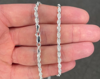 May include: A silver rope chain necklace with a lobster clasp.