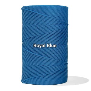 May include: A spool of royal blue cotton cord. The tightly wound cord is a vibrant shade of blue, with the words "Royal Blue" printed on the front. The cord is suitable for various crafting projects.