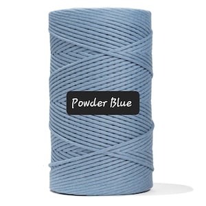 May include: A cylindrical spool of powder blue macrame cord. The cord is tightly wound, creating a textured surface. The text "Powder Blue" is displayed on a black label.