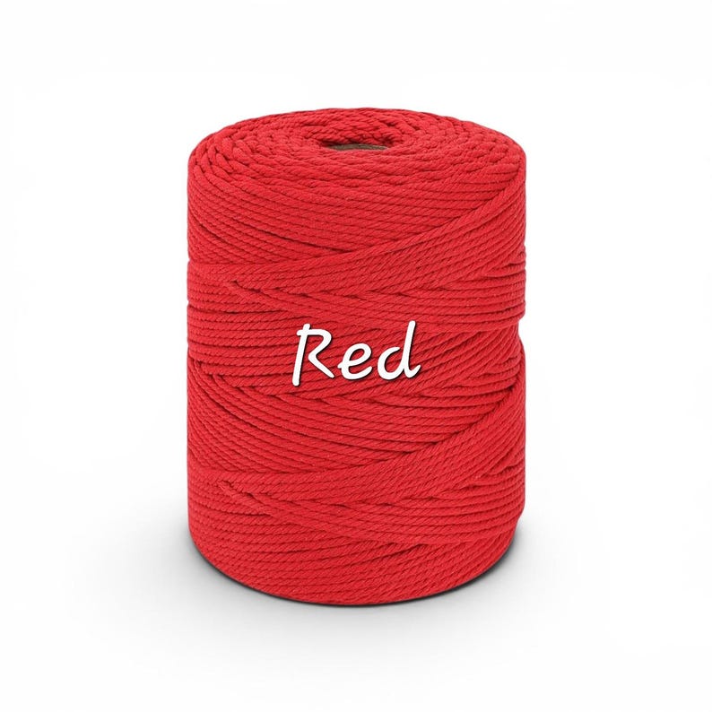 May include: A cylindrical spool of vibrant red macrame cord featuring a tightly wound, multi-strand twisted texture. The word Red is printed in a white, cursive-style font across the center of the spool, clearly visible against the cord.