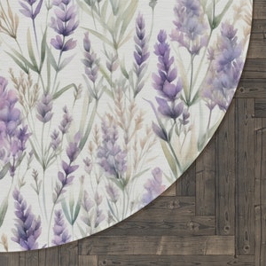 May include: A round rug with a watercolor design of lavender flowers and green leaves on a white background. The rug is placed on a dark wood floor.