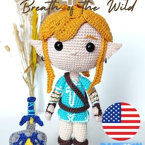 Puede incluir: Muñeca de ganchillo de Link de Breath of the Wild, con peluca rubia, túnica azul y botas marrones. Incluye una espada y un escudo de ganchillo. El texto "Link Breath of the Wild" y "Pattern" también son visibles.