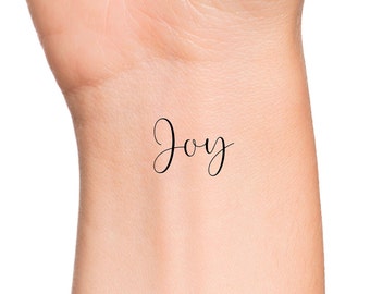 Wrist tattoo saying Joy on Isabelle