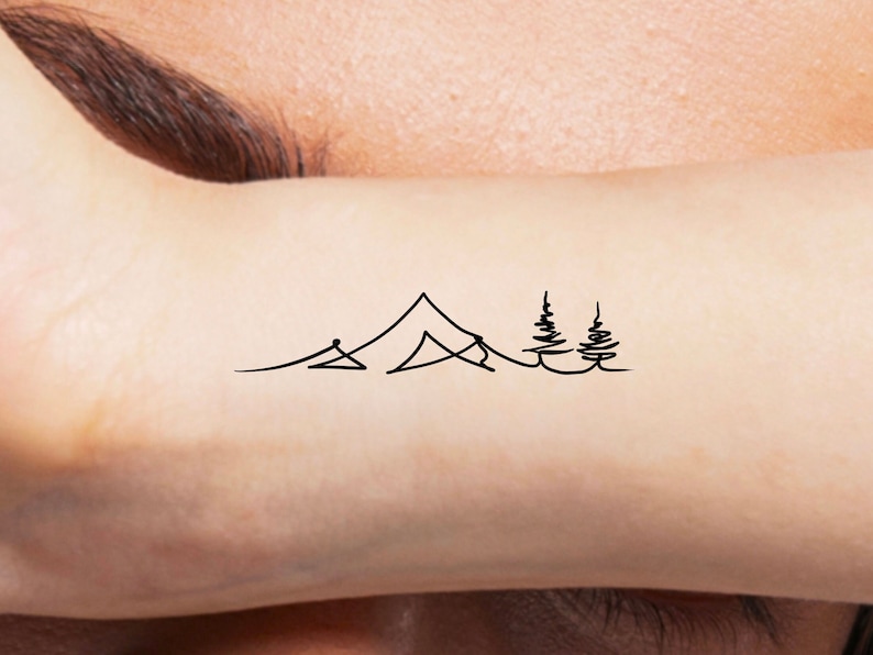 May include: A simple line drawing tattoo design of a mountain range with two pine trees.