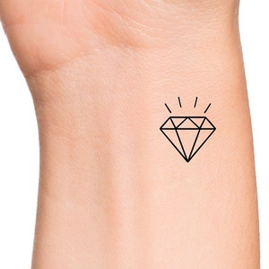 May include: A simple black line drawing of a diamond with rays of light emanating from the top.