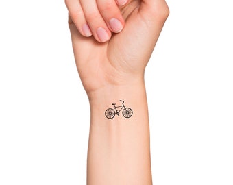 Small bike tattoo on the right inner forearm