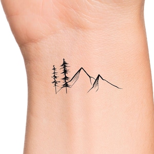 May include: A simple black line drawing tattoo design of a mountain range with three pine trees in front of the mountains.
