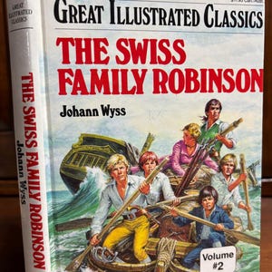 May include: A hardcover book titled "Great Illustrated Classics: The Swiss Family Robinson" by Johann Wyss. The cover features an illustration of a family in a boat on the ocean. Volume #2 is visible.
