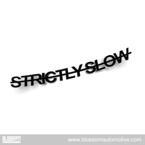 May include: Black text on a white background reads "STRICTLY SLOW" with a line through the word "SLOW". The text has a slight shadow. The bottom of the image has the Blossom Automotive logo and website address.