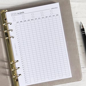 Op de afbeelding: Een witte pagina met een raster en de tekst "2026 in pixels" en "colour key" bovenaan. Het raster heeft kolommen met de maanden van het jaar en rijen die genummerd zijn van 1 tot en met 31.