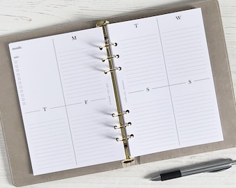 May include: A white weekly planner with a gold binder. The planner has a section for each day of the week, with lines for writing tasks and appointments. The planner also has a section for notes and a section for to-do lists.