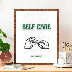 Könnte beinhalten: Ein gerahmter Druck mit weißem Hintergrund und einer schwarzen Linienzeichnung von zwei Händen, die einen Joint drehen. Der Text "SELF CARE" steht in grünen Buchstaben über der Zeichnung. Der Text "100% ORGANIC" steht unter der Zeichnung.