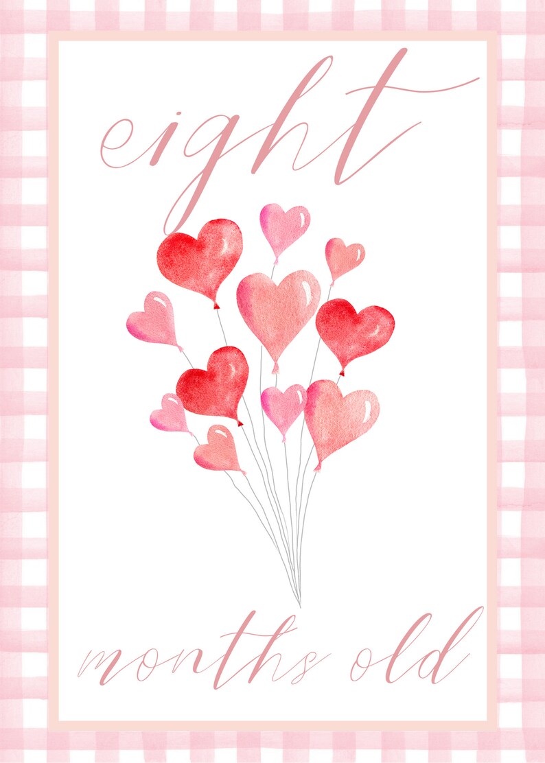 May include: A pink and white gingham background with a white card in the center. The card has the text "eight months old" written in pink cursive. There are eight pink and red heart-shaped balloons in the center of the card.