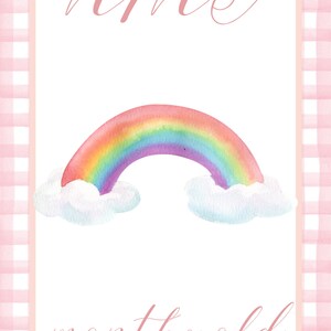 May include: A pink and white gingham background with a white card in the center. The card has the text "nine months old" written in pink cursive. A rainbow with clouds is above the text.