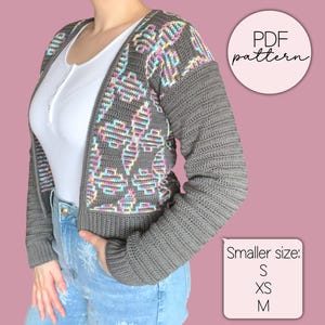Op de afbeelding: Een grijze gehaakte cardigan met een kleurrijk bloemmotief op de voorkant en bovenmouwen. De mouwen zijn effen grijs. De afbeelding bevat de tekst "PDF pattern" en "Smaller size: S, XS, M".