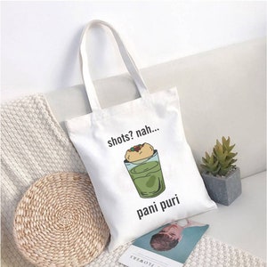May include: White canvas tote bag with a graphic of a glass of pani puri and the text "shots? nah... pani puri".