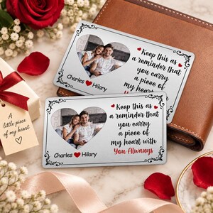 May include: Two rectangular silver metal wallet cards featuring a heart-shaped photo cutout of a couple. The cards display the names Charles and Hilary with a red heart icon and the text: Keep this as a reminder that you carry a piece of my heart with you always.