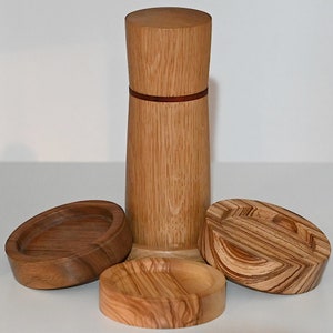 May include: A set of three wooden containers with a natural wood grain finish. The containers are cylindrical in shape and have a red accent band around the middle. The containers are made of wood and have a natural wood grain finish.