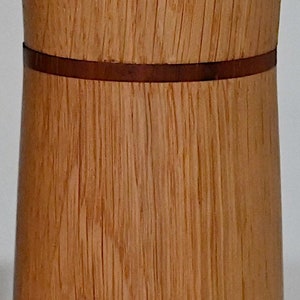 May include: A wooden container with a brown wood grain pattern and a thin brown band around the middle.