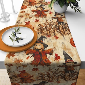 May include: A Halloween table runner with a repeating pattern of scarecrows, pumpkins, and autumn leaves in orange, brown, and beige. The design creates a rustic and festive look. The runner is likely made of fabric, suitable for a dining table.