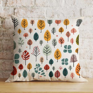 May include: A white cushion with a colourful pattern of stylised trees in shades of yellow, orange, red, green, and blue. The cushion is ideal for adding a touch of nature to any room.
