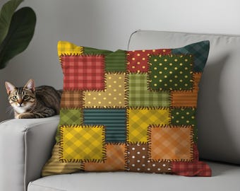 Puede incluir: Un cojín decorativo con diseño de patchwork. El cojín presenta cuadrados de varios patrones, incluyendo cuadros, lunares y rayas, en tonos de rojo, verde, amarillo y naranja. Los cuadrados están cosidos con hilo oscuro.
